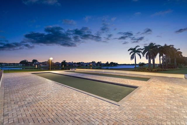 surrounding community with a bocce ball area and a water view