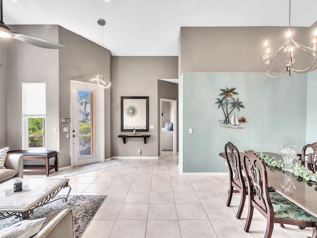 foyer featuring a chandelier, baseboards, light tile patterned floors, and a ceiling fan