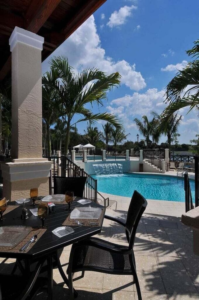 community pool with fence and a patio area