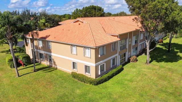 5876 Regal Glen Dr Unit 209, Boynton Beach, FL 33437 - rear view of property featuring stucco siding, a yard, and a tiled roof