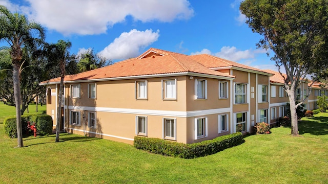 5876 Regal Glen Dr Unit 209, Boynton Beach, FL 33437 - view of home's exterior featuring stucco siding, a lawn, and a tile roof