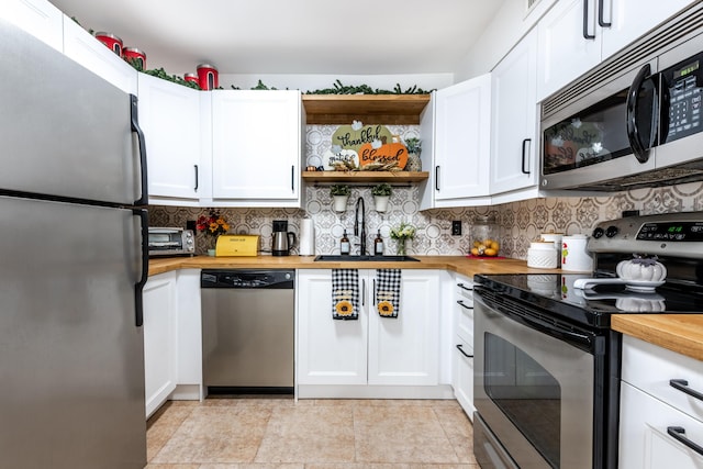9930 Pineapple Tree Dr Unit 202, Boynton Beach, FL 33436 - kitchen featuring appliances with stainless steel finishes, butcher block countertops, a sink, open shelves, and white cabinetry