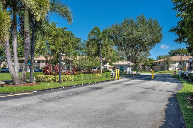 9930 Pineapple Tree Dr Unit 202, Boynton Beach, FL 33436 - view of asphalt road featuring street lighting, a residential view, curbs, and a gated entry