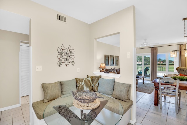 living room featuring ceiling fan, light tile patterned floors, and baseboards