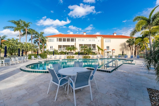 community pool featuring a patio and fence
