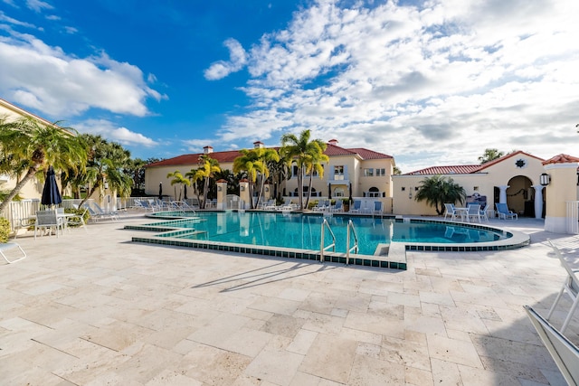 community pool featuring a patio area and fence