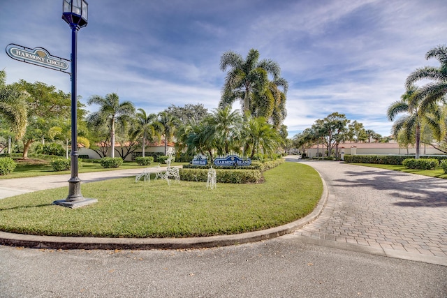 view of home's community featuring decorative driveway and a yard