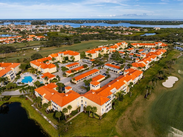 drone / aerial view of a large body of water, a local golf course, and apartment complex / building