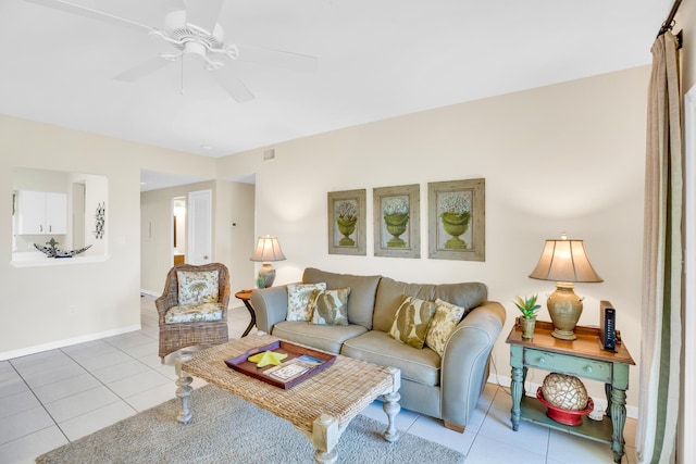 living room with tile patterned floors, a ceiling fan, and baseboards