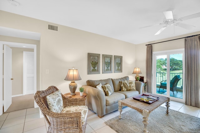 living area with light tile patterned floors, a ceiling fan, and baseboards