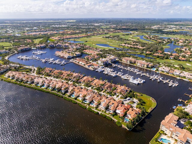 aerial view of property's location featuring a nearby body of water and a marina