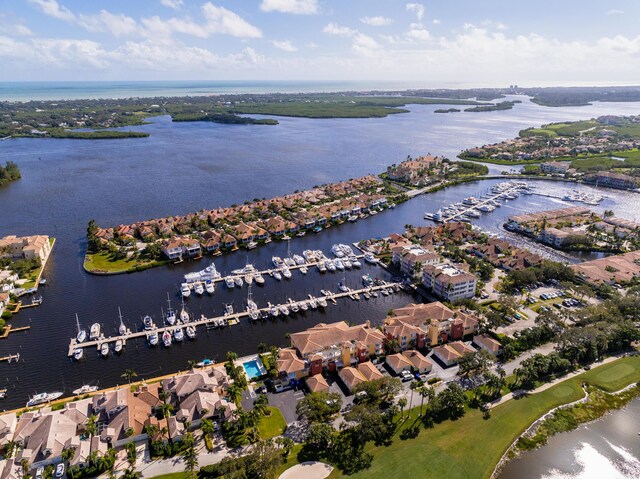 aerial view of property and surrounding area with a large body of water, numerous boat docks, and nearby suburban area