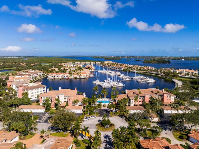 drone / aerial view of a nearby body of water and a marina
