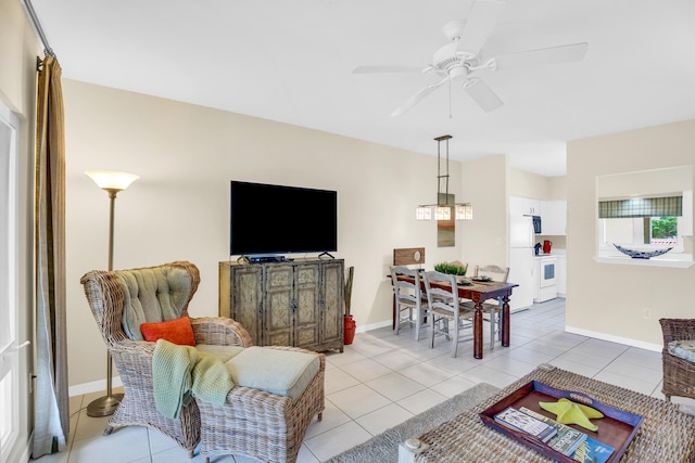 living area with ceiling fan, light tile patterned floors, and baseboards
