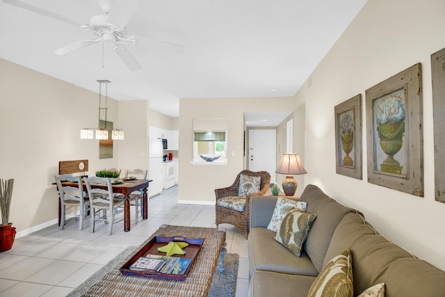 living room with light tile patterned floors, baseboards, and a ceiling fan