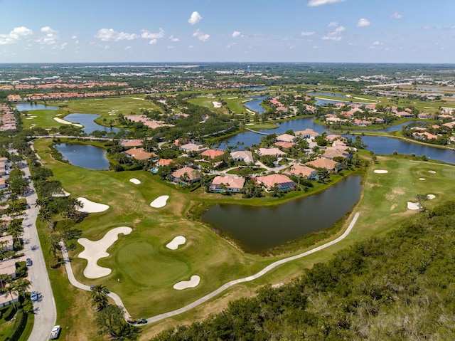 aerial view of property and surrounding area with nearby suburban area, a golf course, and a nearby body of water