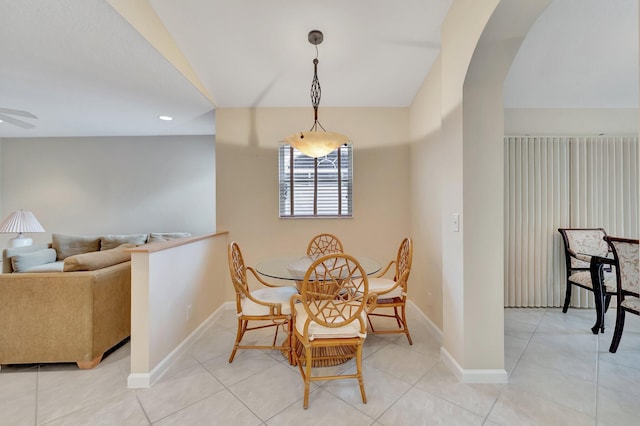 dining area with arched walkways, baseboards, recessed lighting, light tile patterned floors, and ceiling fan