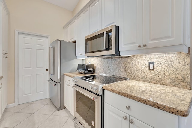kitchen featuring appliances with stainless steel finishes, white cabinetry, light tile patterned floors, and tasteful backsplash