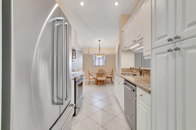 kitchen featuring appliances with stainless steel finishes, a sink, white cabinetry, light tile patterned flooring, and recessed lighting