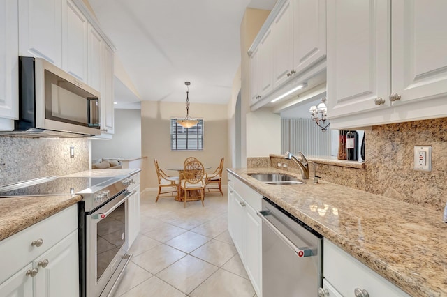 kitchen with appliances with stainless steel finishes, a sink, decorative backsplash, and white cabinetry