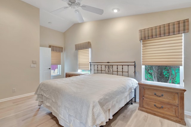 bedroom featuring light wood-style flooring, baseboards, lofted ceiling, and ceiling fan
