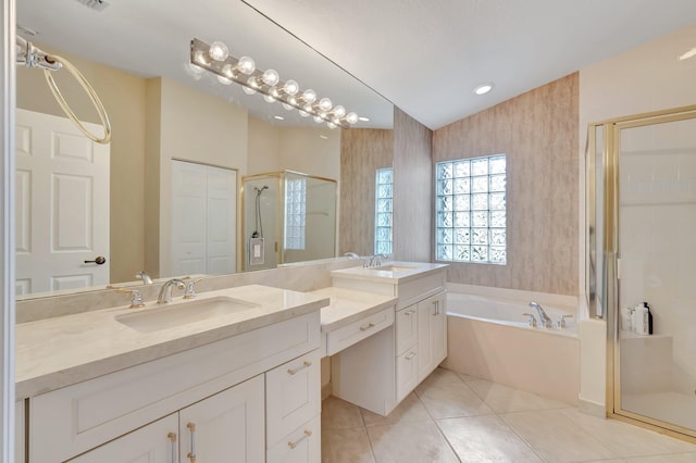 bathroom with a stall shower, a bath, tile patterned floors, and vanity