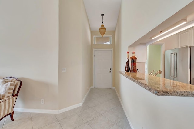 entryway with light tile patterned floors and baseboards