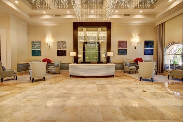 community lobby with a high ceiling, ornamental molding, and recessed lighting