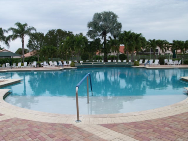 community pool featuring fence and a patio area