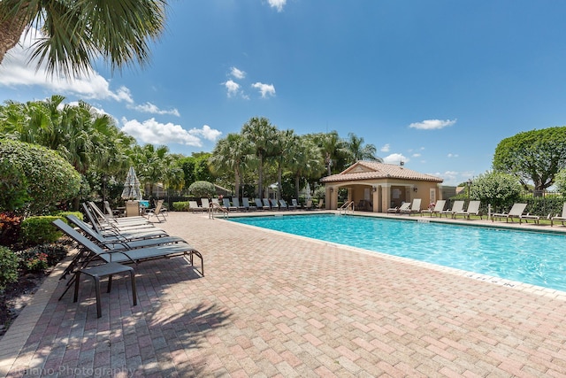 community pool featuring fence and a patio