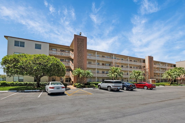 view of apartment building / complex with uncovered parking