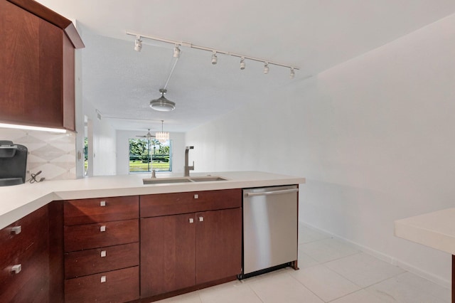 kitchen with stainless steel dishwasher, a sink, light countertops, backsplash, and rail lighting