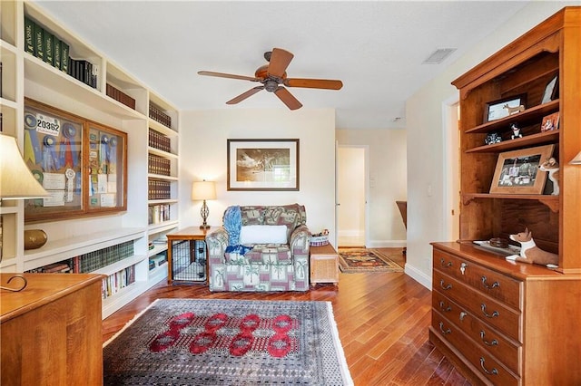living area with ceiling fan, wood finished floors, and baseboards