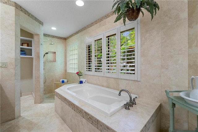 bathroom featuring a walk in shower, tile walls, a bath, and recessed lighting