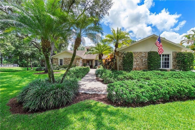 view of front of home featuring stone siding and a front lawn