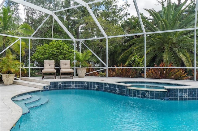 view of swimming pool featuring a patio area, a pool with connected hot tub, and a lanai