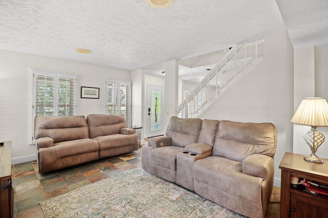 2414 SW Love Ct, Palm City, FL 34990 - living room featuring a textured ceiling, baseboards, stairs, and stone finish floors