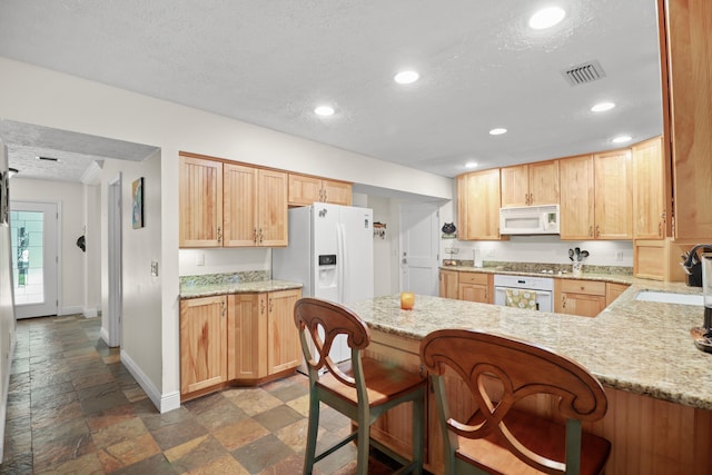 2414 SW Love Ct, Palm City, FL 34990 - kitchen featuring white appliances, a sink, stone tile flooring, baseboards, and a peninsula