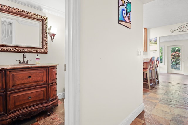 2414 SW Love Ct, Palm City, FL 34990 - hall with stone tile flooring, a sink, baseboards, and crown molding