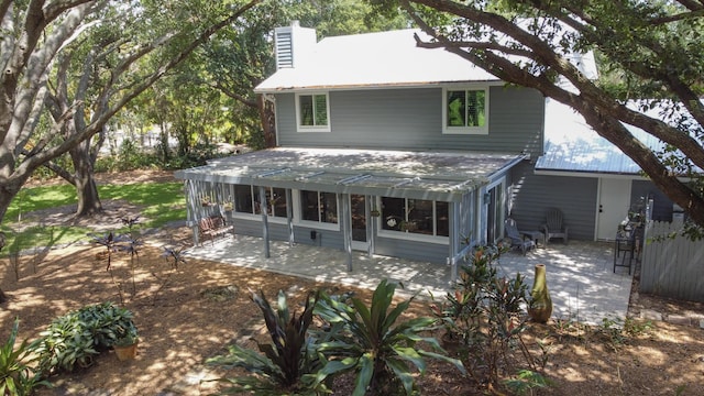 2414 SW Love Ct, Palm City, FL 34990 - rear view of house featuring a patio area, a chimney, and a sunroom