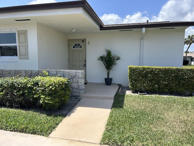 property entrance with stucco siding