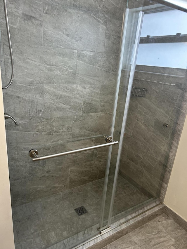 bathroom featuring a shower stall and baseboards
