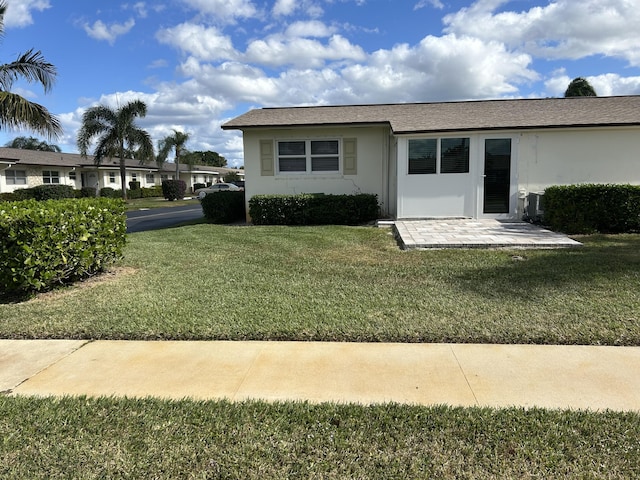 view of front of home with stucco siding and a front lawn