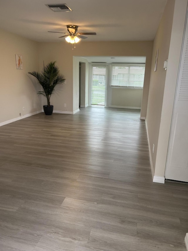 unfurnished room with a ceiling fan, baseboards, and wood finished floors
