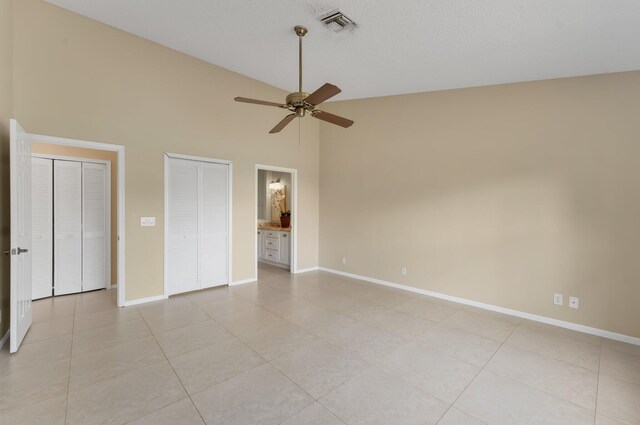 6616 Marissa Cir, Lake Worth, FL 33467 - unfurnished bedroom featuring high vaulted ceiling, baseboards, two closets, light tile patterned floors, and ensuite bathroom