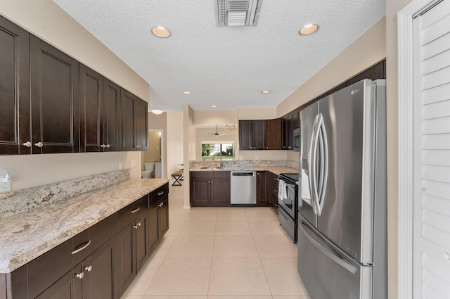 6616 Marissa Cir, Lake Worth, FL 33467 - kitchen featuring appliances with stainless steel finishes, dark brown cabinets, a textured ceiling, a sink, and light tile patterned floors