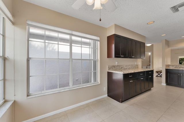 6616 Marissa Cir, Lake Worth, FL 33467 - kitchen featuring light tile patterned floors, a textured ceiling, a ceiling fan, baseboards, and light stone countertops