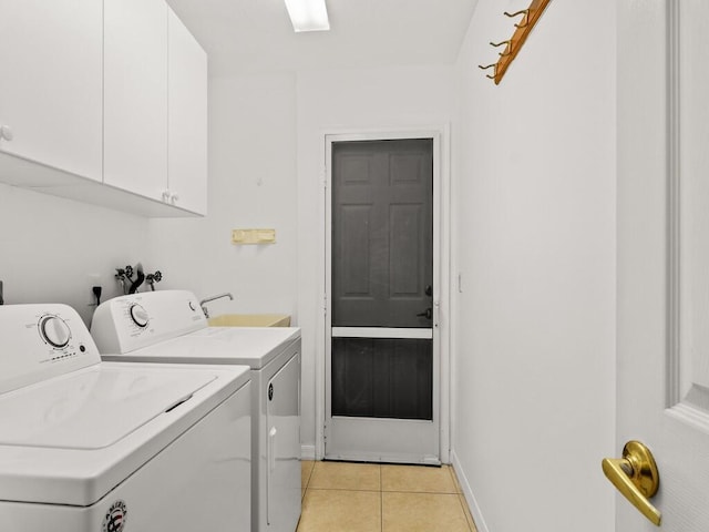 washroom with cabinet space, washing machine and clothes dryer, light tile patterned flooring, and baseboards