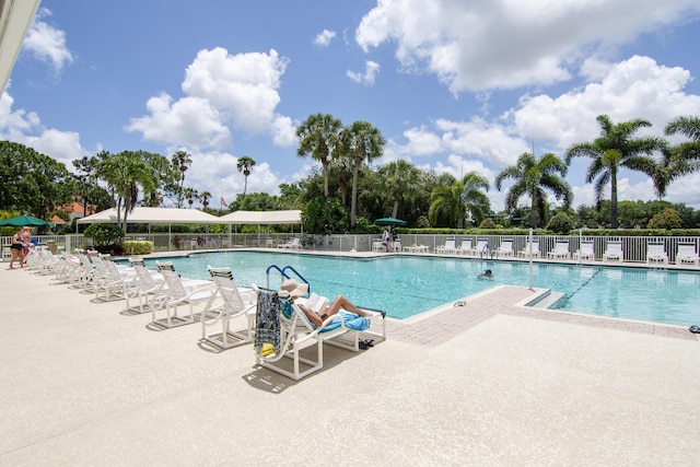 community pool featuring fence and a patio