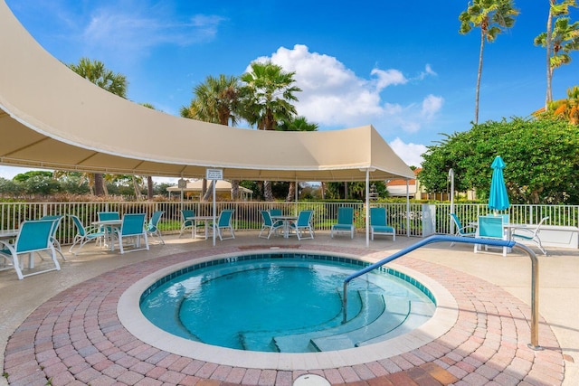 view of swimming pool with a patio, fence, a swimming pool, and outdoor dining space